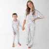 A woman and a young boy wearing matching pajama sets that have blue and white patterned featuring silly gooses in a beach theme with watermelon, beach theme and palm trees.