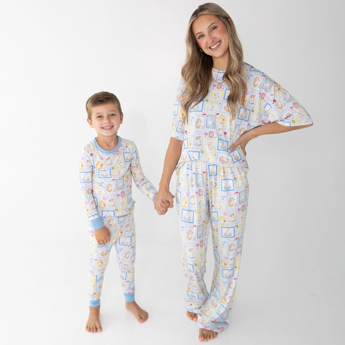 A woman and a young boy wearing matching pajama sets that have blue and white patterned featuring silly gooses in a beach theme with watermelon, beach theme and palm trees.