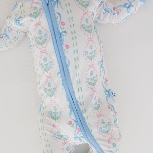 Baby romper with floral pattern and blue zipper on a white background