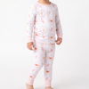 A toddler standing against a plain white studio background, wearing a long-sleeve pajama top and matching pajama pants with a light pink trim, featuring ice cream cone, ice cream sundae, milk shake.