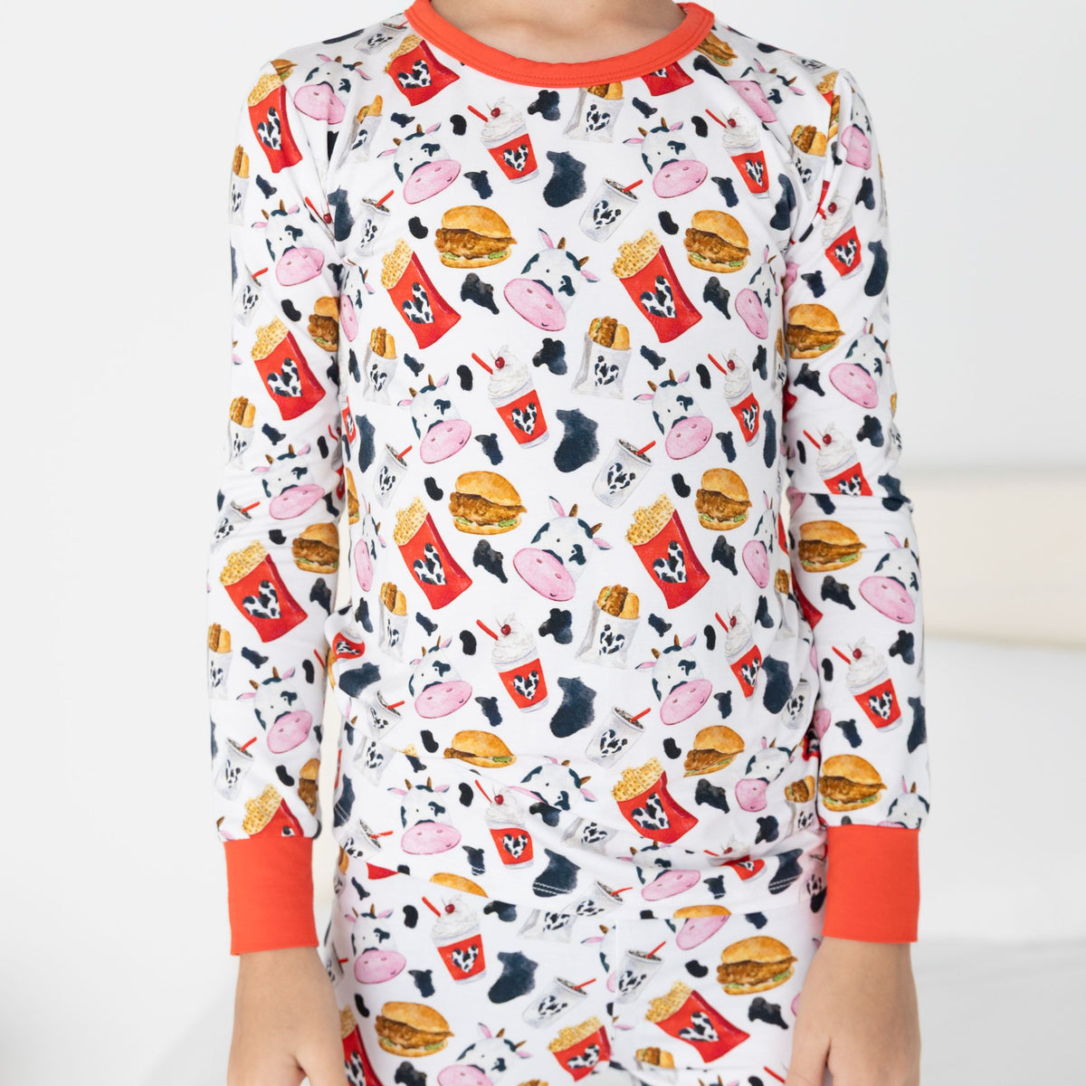 Child wearing a long-sleeve shirt with a colorful pattern on a white background