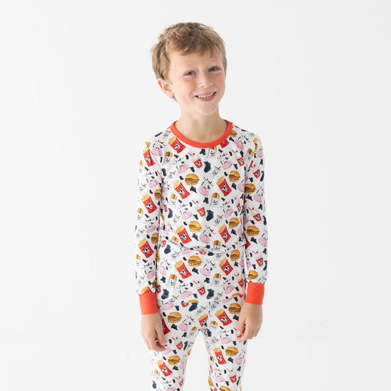 Child wearing a colorful pajama set with chicken nugget design on a white background