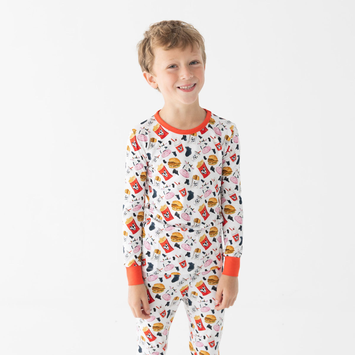 Child wearing a colorful pajama set with chicken nugget design on a white background